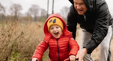 Dad teaching young boy how to ride a bike