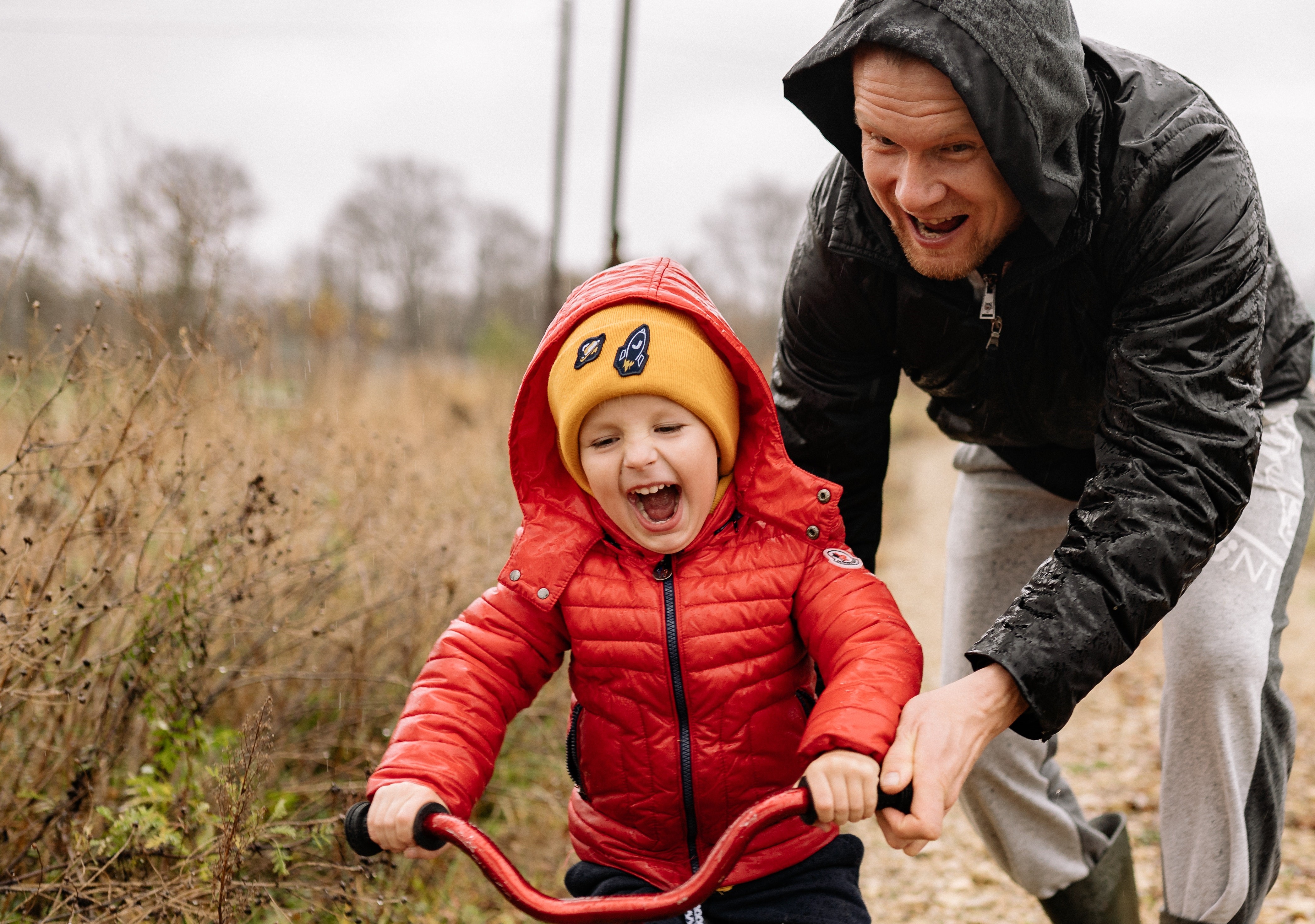 Dad teaching young boy how to ride a bike