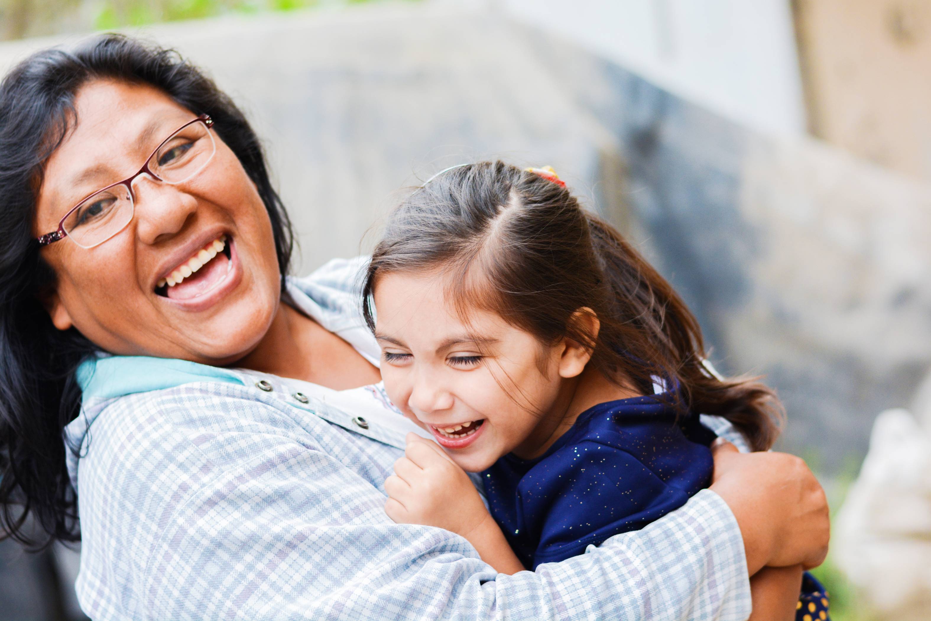 foster-mother-hugging-laughing-smiling-with-young-female-foster-child