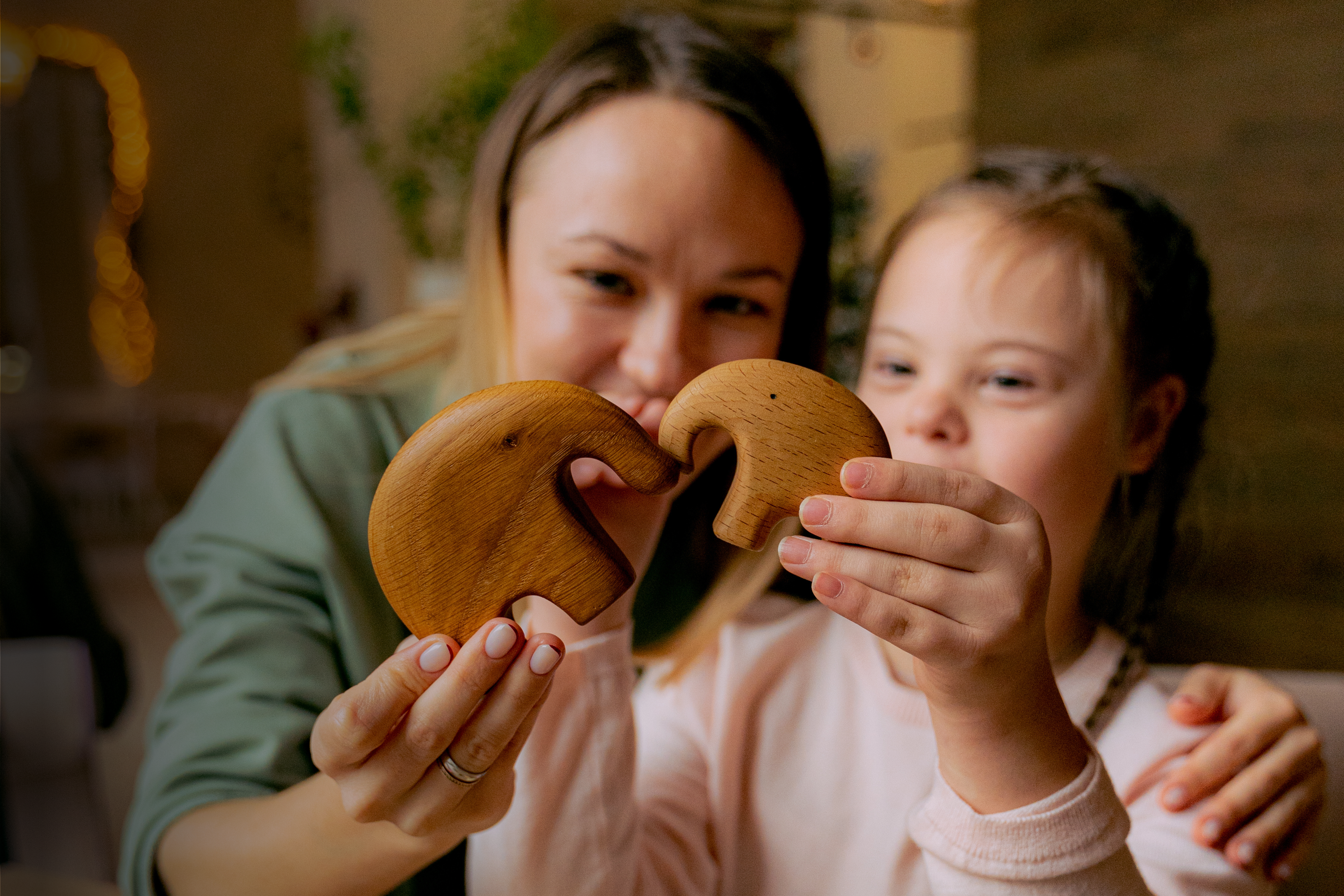 lady-and-girl-side-by-side-holding-up-wooden-elephant-ornaments
