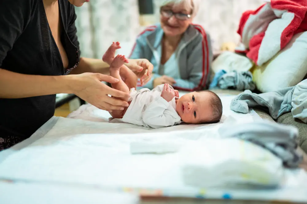 Two women changing a baby's nappy