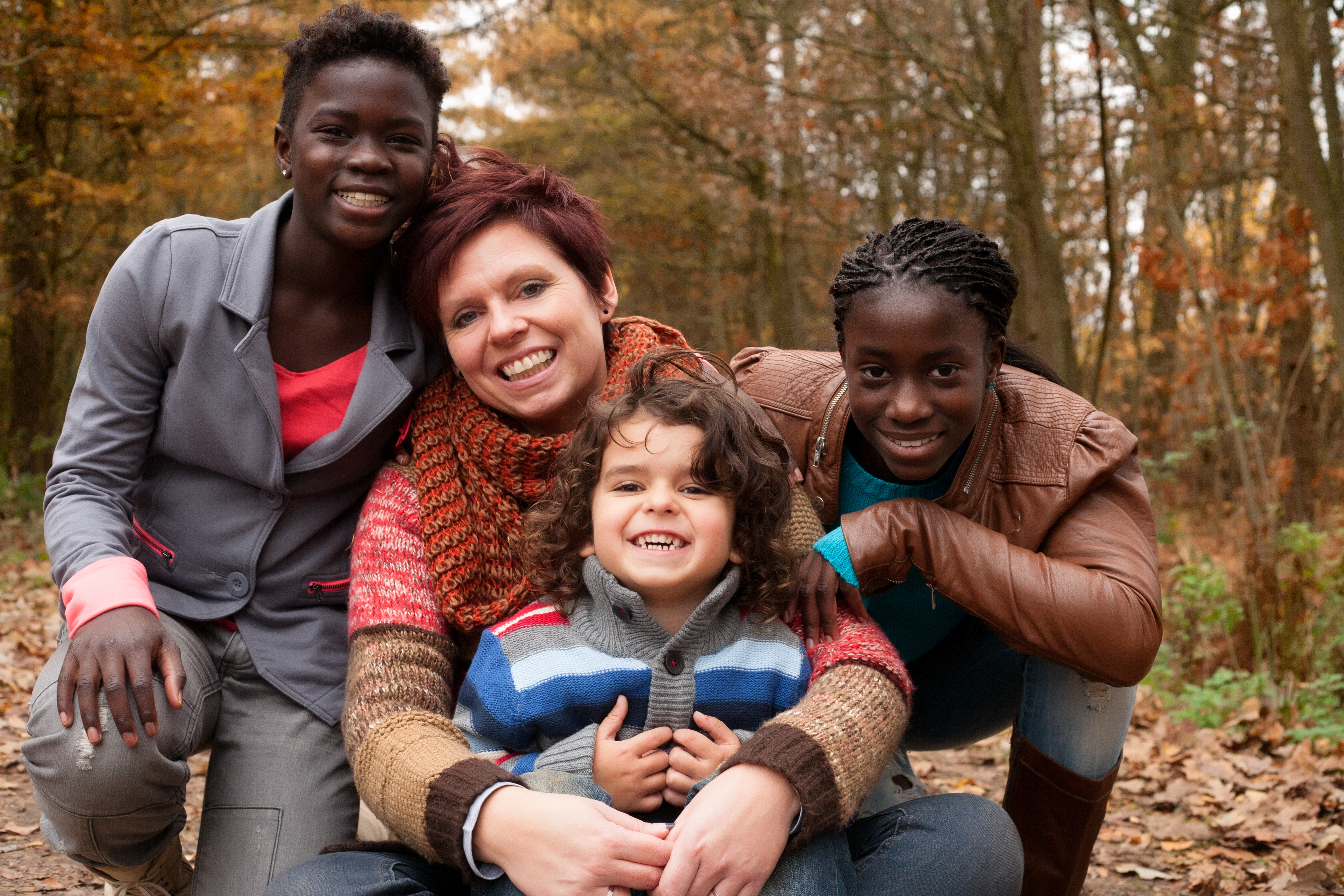 red-hair-woman-with-foster-family-smiling-in-forest