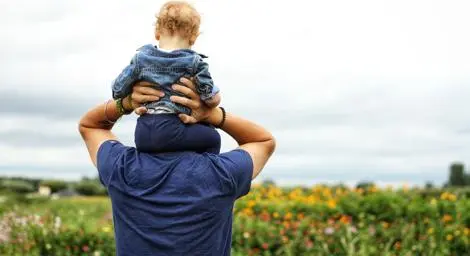 toddler-on-mans-shoulders-walking-through-flowers